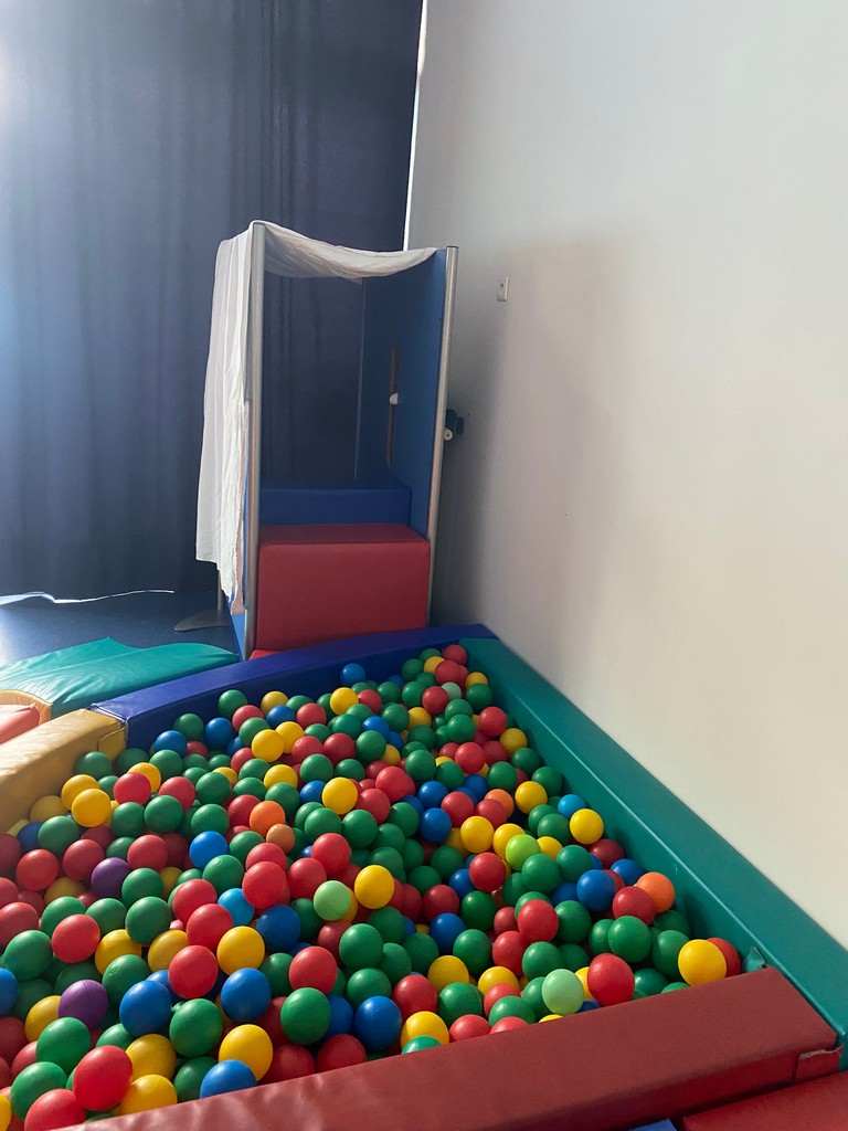 Enfant en séance de psychomotricité relationnelle à Braine-l’Alleud, jeu libre avec mousses et tissus